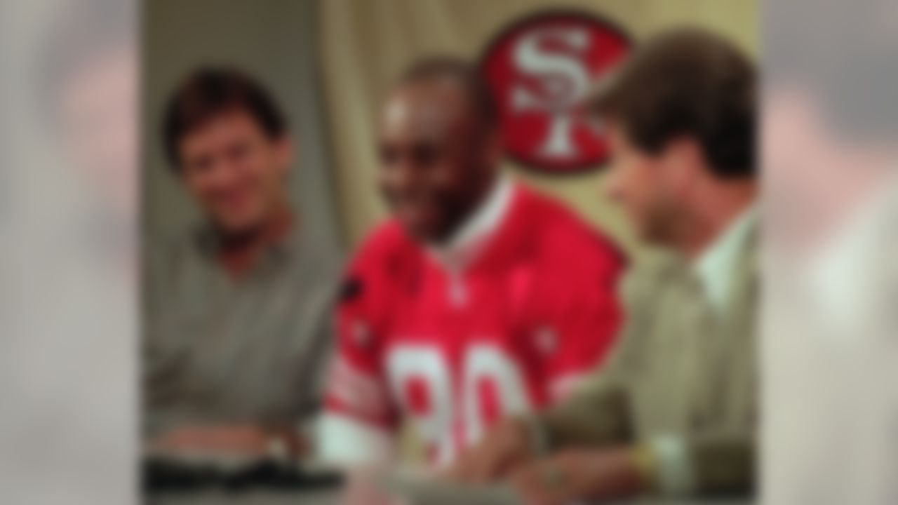 San Francisco 49ers president Carmen Policy, right, wide receiver Jerry Rice, center, and Rice's agent Jim Steiner, left, smile at a news conference at the 49ers training camp in Santa Clara, Calif., Wednesday, Aug. 28, 1996. Rice signed a multi-year $32 million contract with the 49ers designed to keep him with the team until his retirement. (AP Photo/Paul Sakuma)