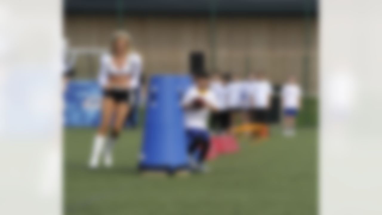An Oakland cheerleader chases a child during a drill at a football clinic in London. The Oakland Raiders and the Miami Dolphins play in the NFL International Series at Wembley Stadium in London on Sunday, Sept 28. (Sean Ryan/NFL)