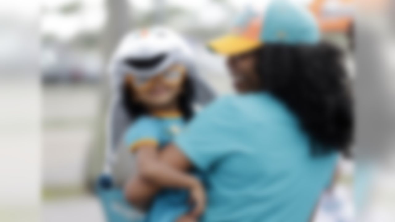 Miami Dolphin fans Andrea Randall, 2, and her mother Elizabeth Randall, of Miami, tailgate before an NFL football game against the New York Jets, Sunday, Dec. 28, 2014, in Miami Gardens, Fla. (AP Photo/Wilfredo Lee)