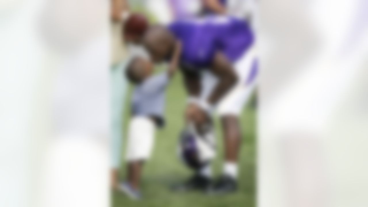 Minnesota Vikings running back Adrian Peterson gets a kiss from his son Adrian Jr. at the end of practice at NFL football training camp, Monday, July 29, 2013, in Mankato, Minn. (AP Photo/Charlie Neibergall)