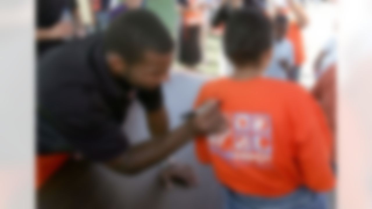 Braylon Edwards signs a shirt from one of The Home Depot associates volunteering onsite. (Photo by Alan Marler/CIA Stock Photography, Inc.)