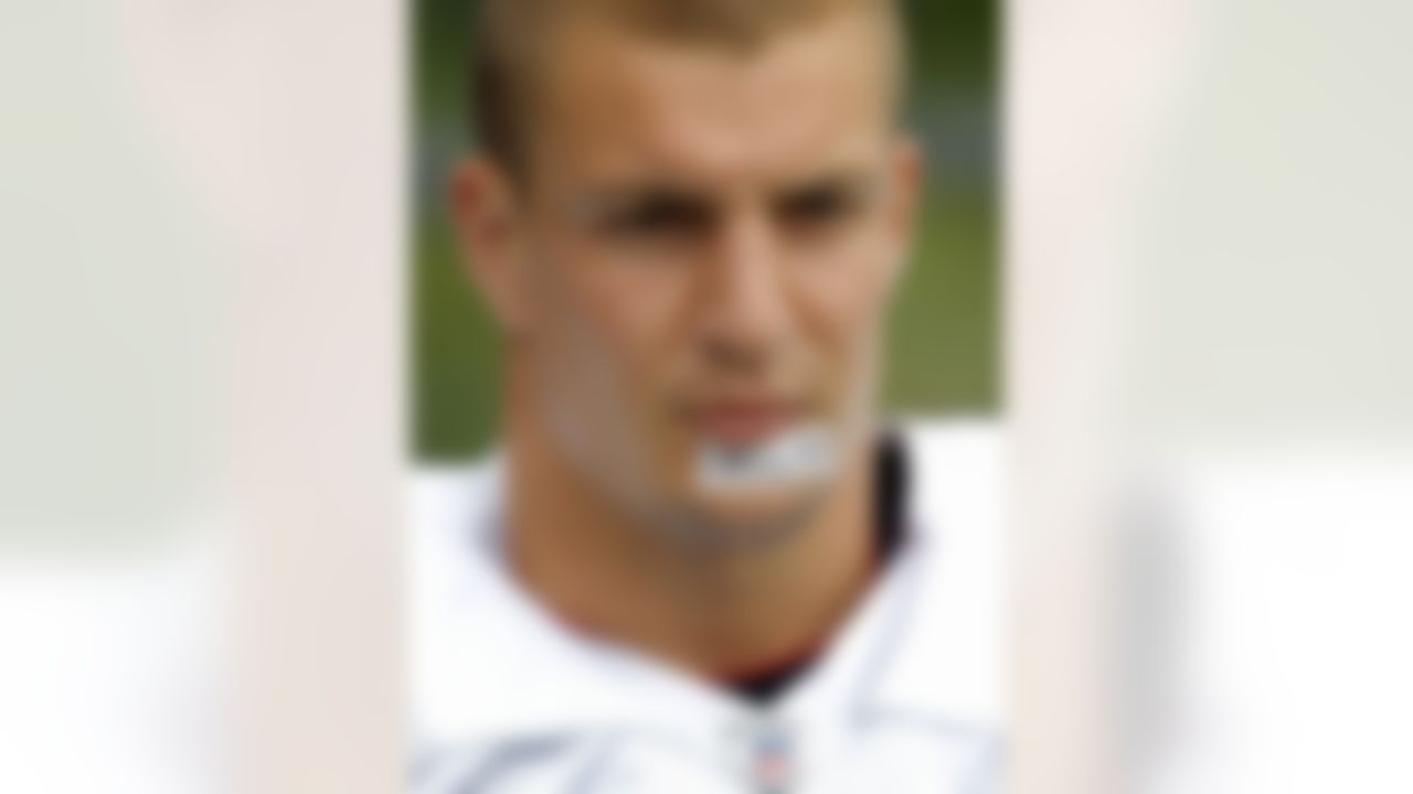 New England Patriots tight end Rob Gronkowski (87) steps onto the field wearing tape on his chin with the words "hard work" before an NFL football training camp in Foxborough, Mass., Sunday, July 29, 2012. (AP Photo/Steven Senne)