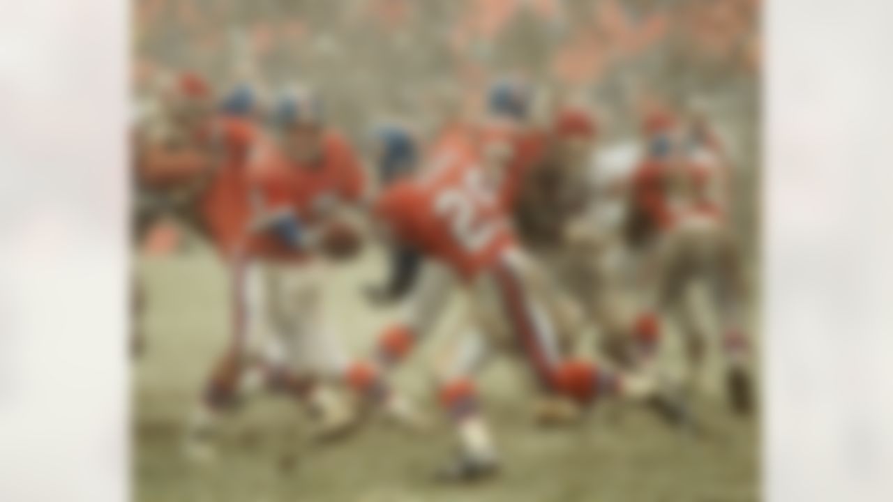 Denver Broncos quarterback John Elway (7) hands the ball off to running back Aaron Craver (29) as heavy snow falls during the third quarter against the Kansas City Chiefs at Denver's Mile High Stadium on Sunday, Oct. 22, 1995. Craver was stopped at the line of scrimmage on the play. (AP Photo/Ed Andrieski)