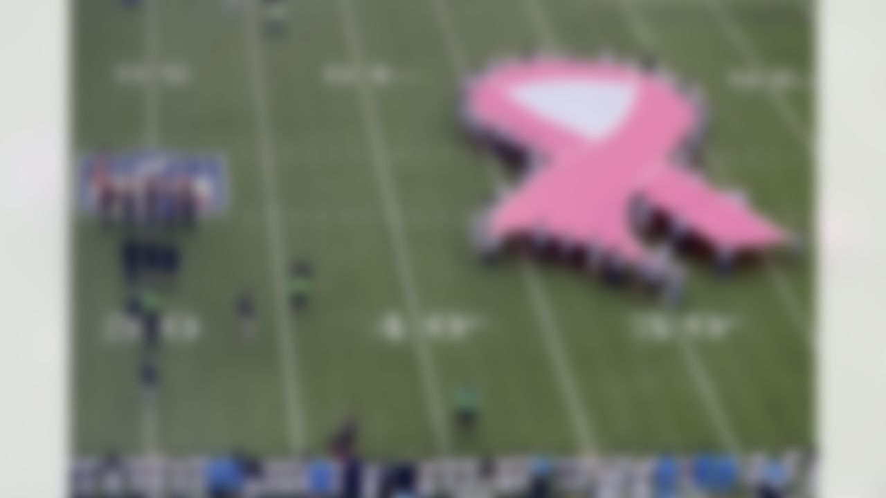 A ribbon in honor of cancer awareness is displayed on the field during the singing of the national anthem prior to an NFL football game between the New York Giants and the Los Angeles Chargers, Sunday, Oct. 8, 2017, in East Rutherford, N.J.