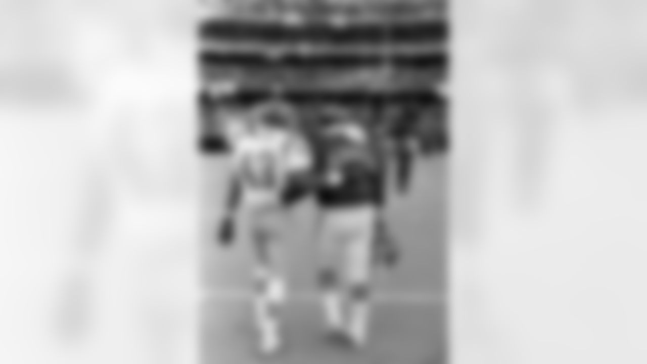 San Diego Chargers defensive back Bob Gregor (43), left, walks off the field with a Cincinnati Bengal in Cincinnati on Jan. 10, 1982. The Bengals defeated the Chargers 27-7 in the AFC championship game. (AP Photo/Harold P. Matosian)