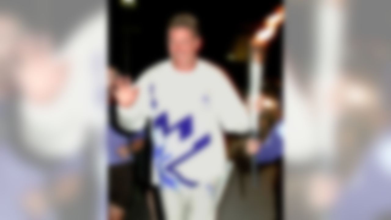Former Miami Dolphins quarterback Dan Marino carries the Olympic flame down Miami's Biscayne Boulevard, Saturday, Dec. 8, 2001, to conclude Olympic torch run festivities in South Florida. (AP Photo/Andy Newman)