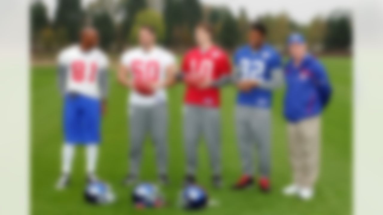 Cheerio, mates -- those are some sporting football kits, indeed! New York Giants Amani Toomer, left, Shaun O'Hara, 2nd left, Eli Manning, centre, Michael Strahan, 2nd right, and coach Tom Coughlin pose for photographers at the Chelsea soccer team's training ground, Cobham, England Friday Oct. 26, 2007. The New York Giants will face the Miami Dolphins at Wembley Sunday Oct. 28, 2007. (AP Photo/Tom Hevezi)
