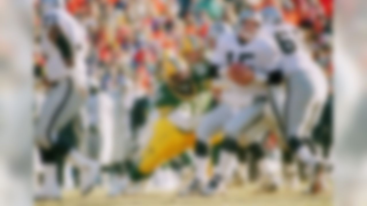 Green Bay Packers' Reggie White (92) sacks Los Angeles Raiders quarterback Jeff Hostetler (15) during the second quarter in Green Bay, Wisconsin on Sunday, Dec. 26, 1993. White was credited with 2.5 sacks in the game and Hostetler left in the third quarter with a concussion. The Packers won, 28-0, thus earning a playoff spot for the first time in regular season since 1972. Raiders player Max Montoya (65) is at right. (AP Photo/Morry Gash)