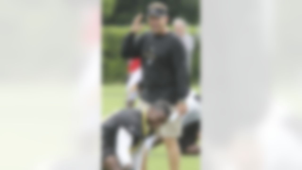 New Orleans Saints coach Sean Payton talks with safety Roman Harper during stretching exercises at the start of practice at the club's NFL football training facility in Metairie, La., Friday, June 4, 2010. (AP Photo/Bill Haber)