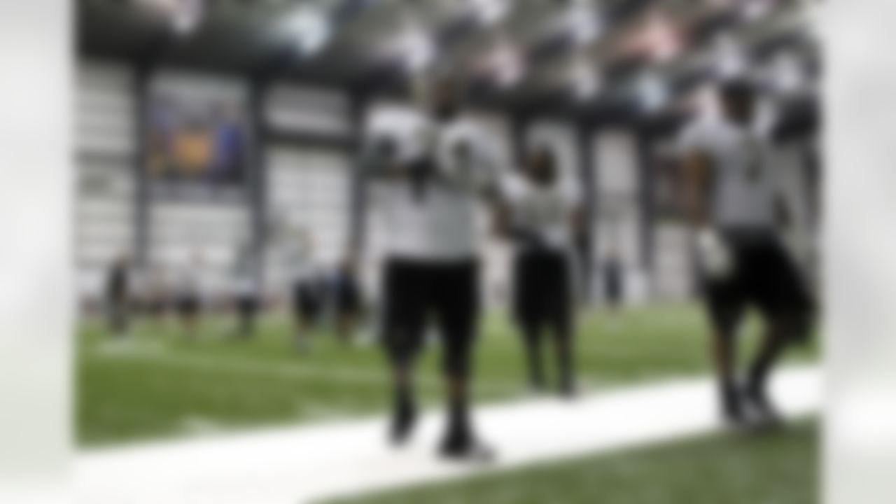 New Orleans Saints offensive tackle Jermon Bushrod (74), tackle Aderious Simmons (68) and offensive tackle Charles Brown (71) walk off the field with a newly installed banner of suspended head coach Sean Payton displayed in the background at the conclusion of NFL football training camp in their indoor training facility in Metairie, La., Friday, July 27, 2012. (AP Photo/Gerald Herbert)