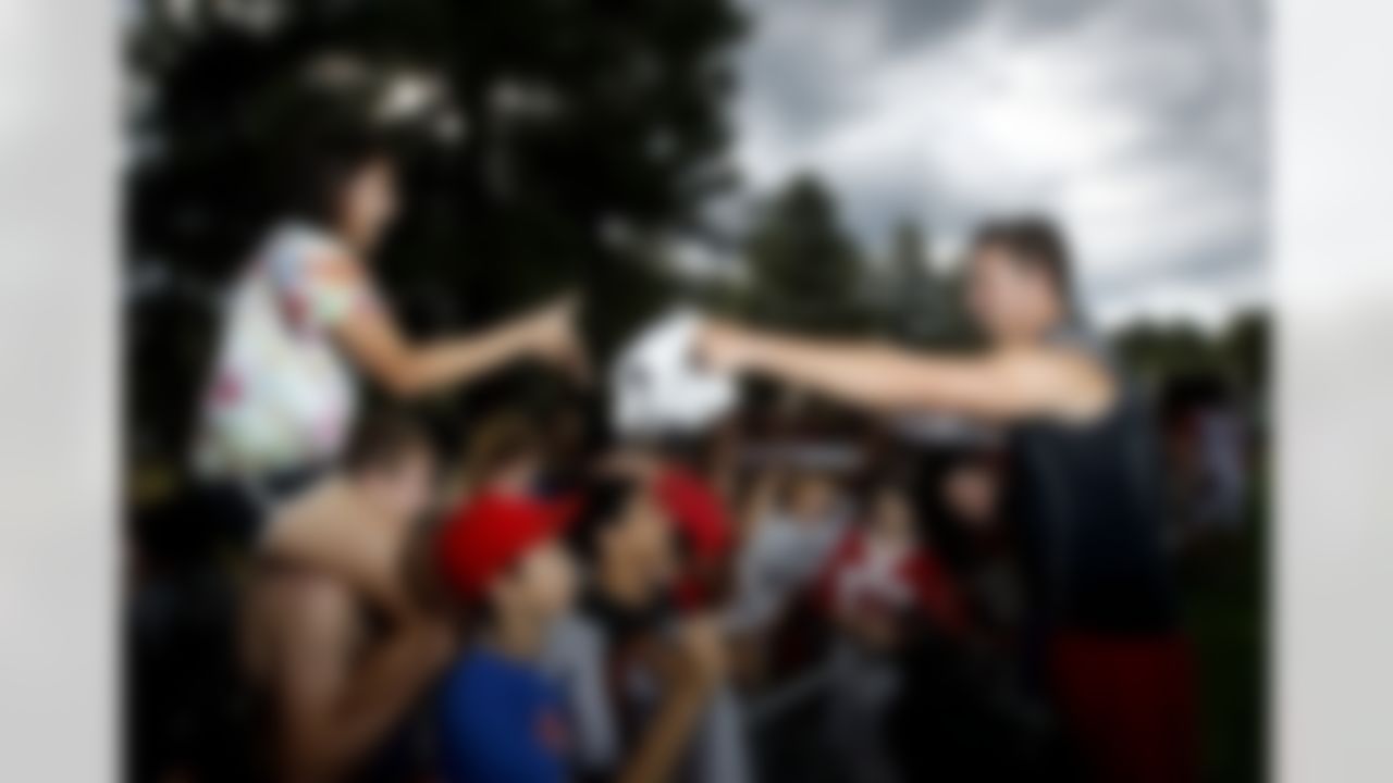 As storm clouds move in, Arizona Cardinals quarterback Kevin Kolb signs autographs for fans after the first day of NFL football training camp at Northern Arizona University, Wednesday, July 25, 2012, in Flagstaff, Ariz. (AP Photo/Ross D. Franklin)
