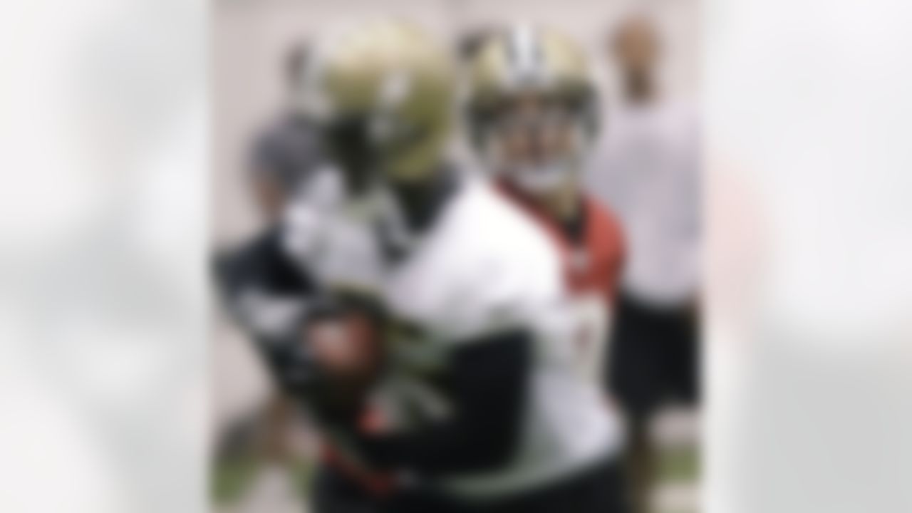 New Orleans Saints quarterback Drew Brees, right, handsoff to running back Reggie Bush during football practice at the team's NFL training facility in Metairie, Thursday, May 27, 2010.(AP Photo/Bill Haber)