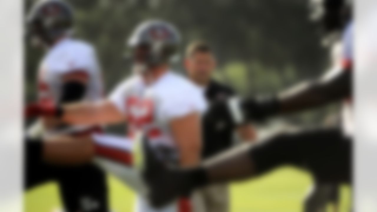 Tampa Bay Buccaneers head coach Greg Schiano, third from left, watches his players stretch during NFL football training camp, Friday, July 27, 2012, in Tampa, Fla. (AP Photo/Brian Blanco)