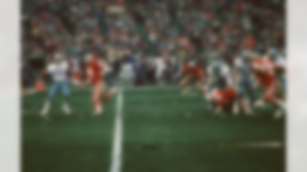 Dallas Cowboys quarterback Danny White (11) looks for a receiver while being pursued by the 49ers Dwaine Board (76) during the NFL football game NFC Championship between the Dallas Cowboys and the San Francisco 49ers in San Francisco, California on January 10, 1982. The 49ers won the game 28-27. (AP Photo/Paul Spinelli)