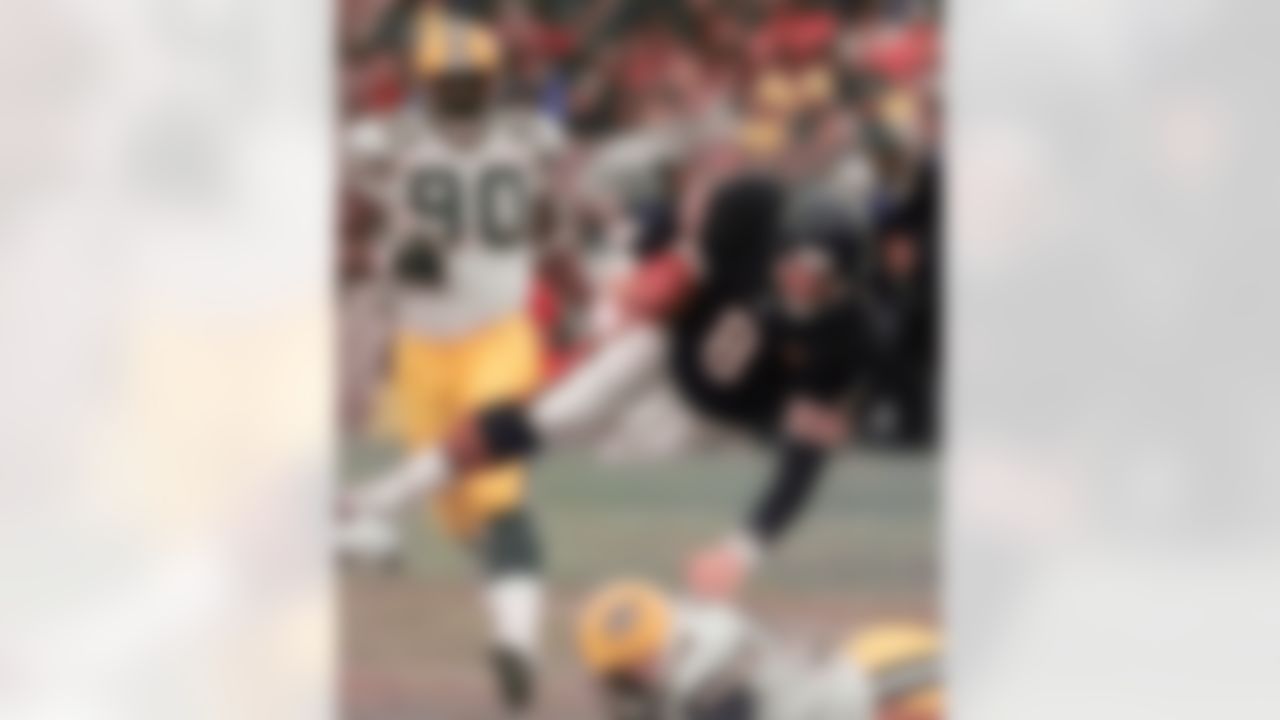 Chicago Bears quarterback Cabe McNown is tripped up after a 6-yard gain by Green Bay Packers' Anthony Davis (50) during the first quarter on Sunday, Dec. 5, 1999. Moving in on the play is the Packers' Vonnie Holliday (90). (AP Photo/Michael S. Green)