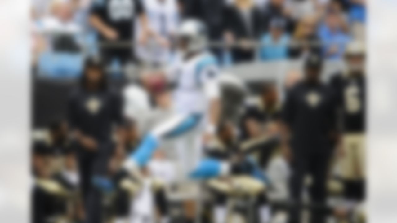 Carolina Panthers quarterback Cam Newton (1) smiles and jumps as he carries the ball past New Orleans Saints safety Roman Harper (41) (bottom right) during an NFL football game, Sunday, September 16, 2012, in Charlotte, North Carolina. The Panthers won 35-27. (AP Photo/Paul Abell)