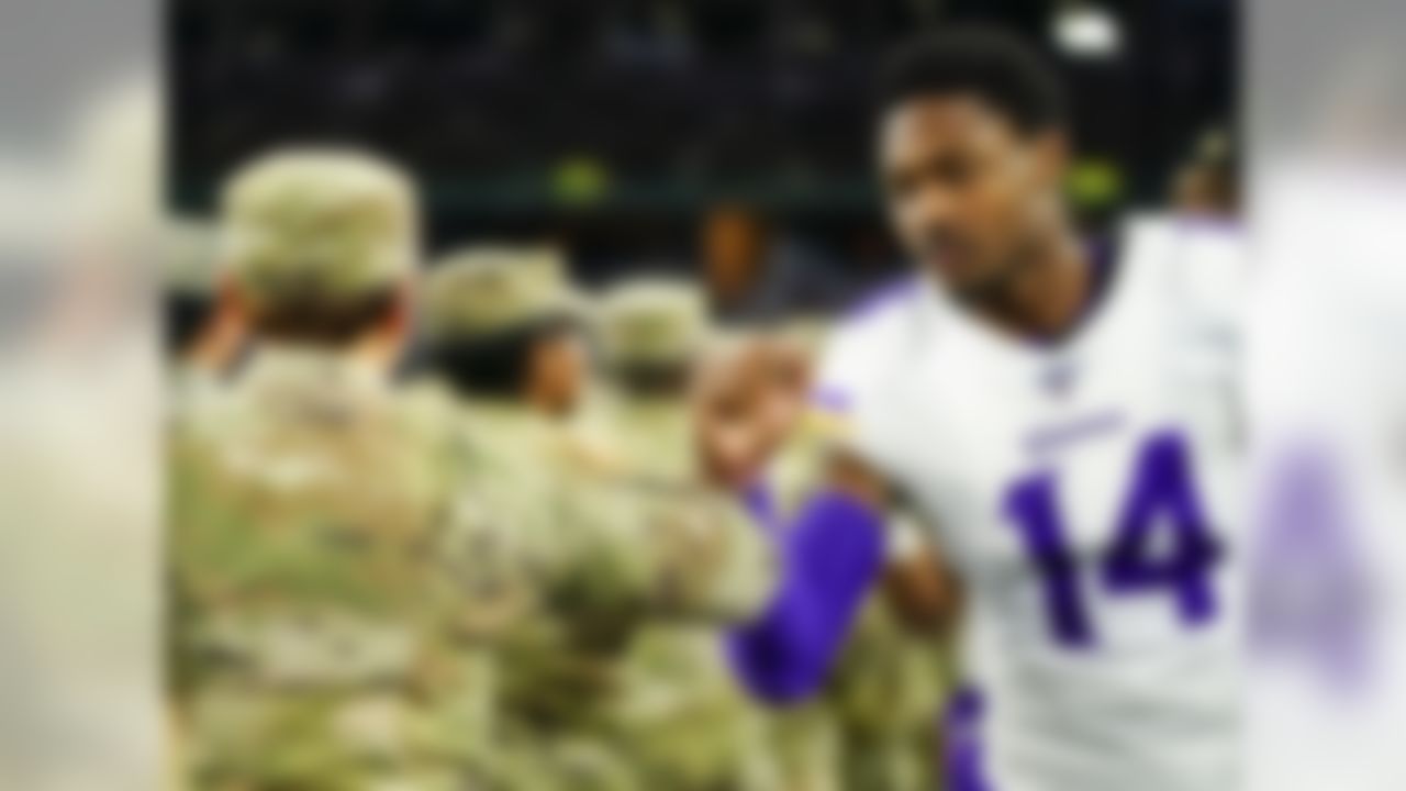 Minnesota Vikings wide receiver Stefon Diggs (14) greets US service members prior to an NFL football game against the Dallas Cowboys, Sunday, Nov. 10, 2019 in Arlington, Texas.