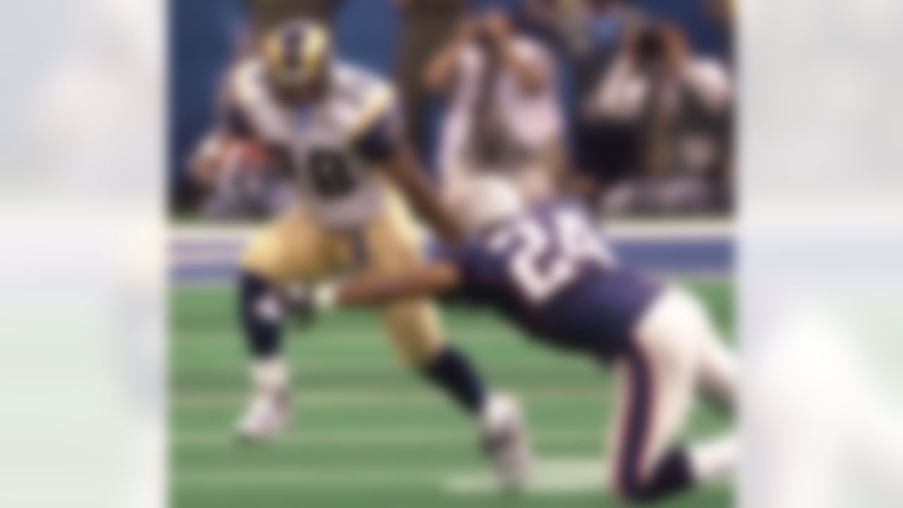 St. Louis Rams running back Marshall Faulk (28) fends of New England Patriots cornerback Ty Law (24) during first-quarter play of Super Bowl XXXVI at the Louisiana Superdome Sunday, Feb. 3, 2002 in New Orleans. (AP Photo/Tony Gutierrez)