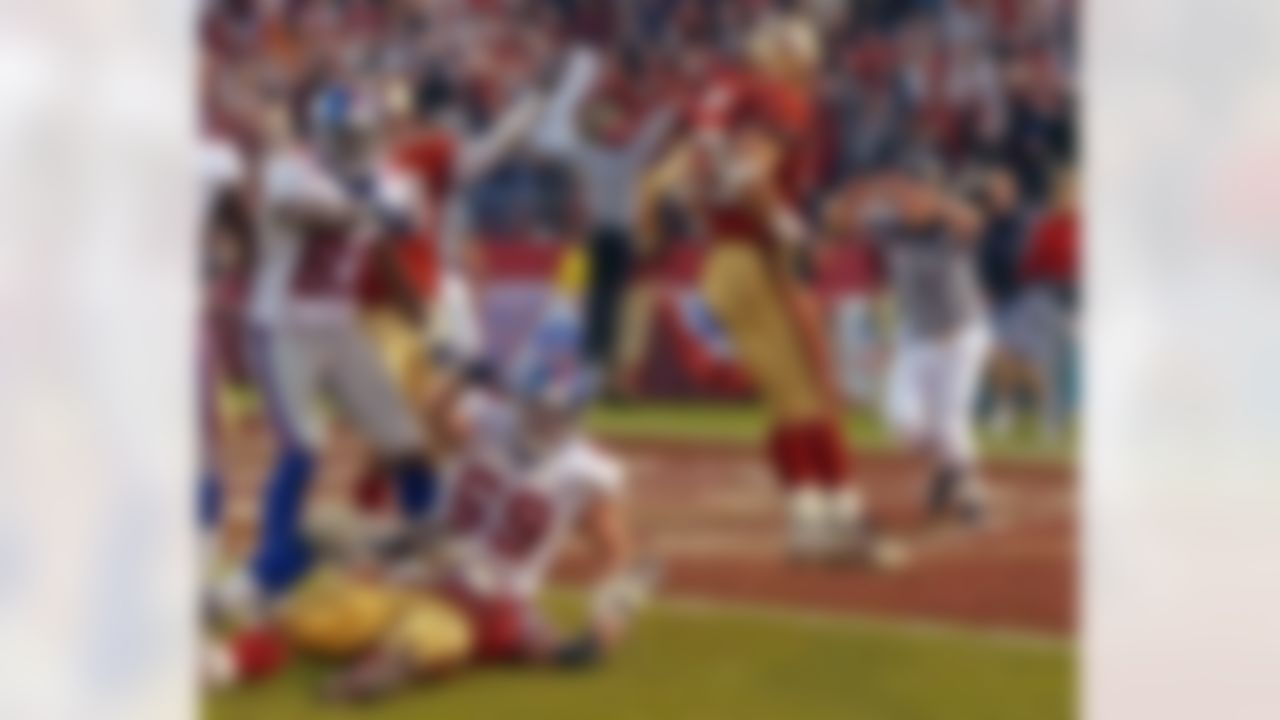 San Francisco 49ers' Chike Okeafor lies on the ground after breaking up up a pass from New York Giants Matt Allen (not shown) to Rich Seubert (69) in the final minutes of the NFC Wild Card playoff game in San Francisco, Sunday, Jan. 5, 2003. Giants' Marcellus Rivers (83) gestures at left. (AP Photo/Julie Jacobson)