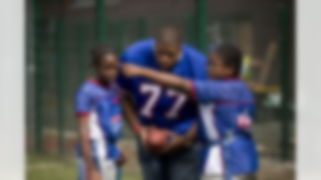 NFL team Buffalo Bills offensive tackle Cordy Glenn talks with youngsters he was coaching during a NFL Summer Bowl tournament for kids from six London schools that have taken part in a football and education programme, at the Black Prince Community Hub in south London, Wednesday, July 15, 2015. The NFL will stage three international series regular-season games in autumn 2015 at Wembley Stadium in London. (AP Photo/Matt Dunham)