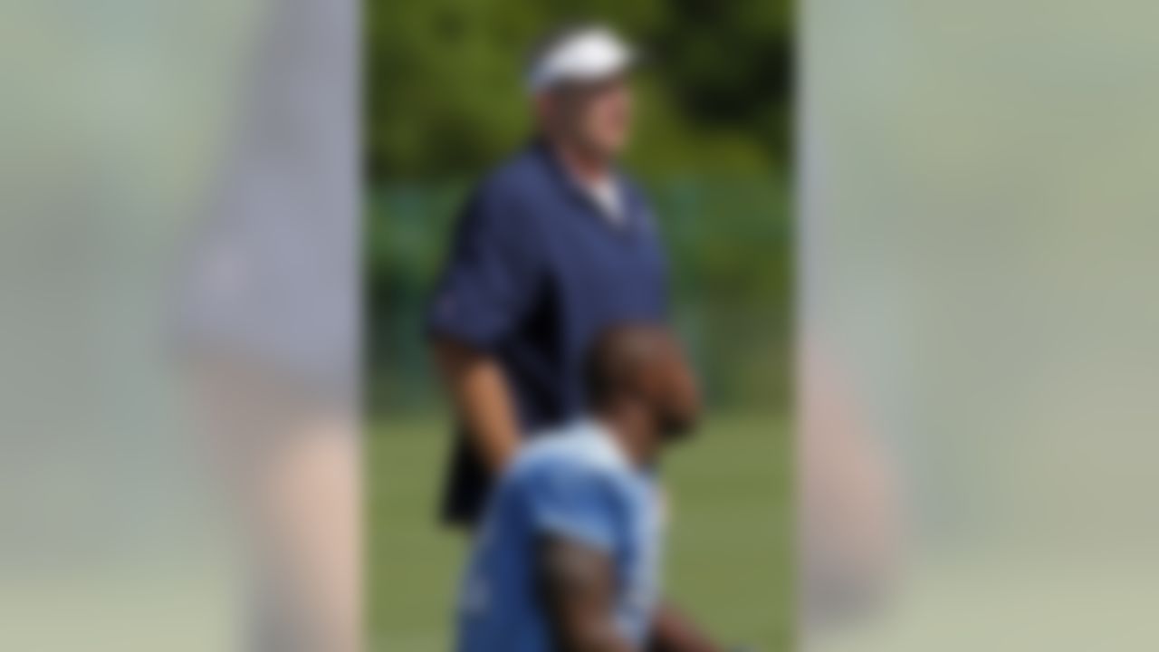 Tennessee Titans head coach Mike Munchak, behind, talks with Will Witherspoon during an NFL football practice at Titans' headquarters Saturday, July 28, 2012 Nashville, Tenn. (AP Photo/Wade Payne)