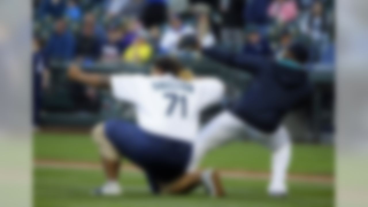 Cleveland Browns first-round draft pick Danny Shelton, a former defensive tackle from the University of Washington, performs Seattle Mariners closing pitcher Fernando Rodney's traditional arrow-shooting motion with Rodney, right, after Shelton threw out the ceremonial first pitch at a baseball game between the Mariners and the Boston Red Sox, Thursday, May 14, 2015, in Seattle. (AP Photo/Ted S. Warren)