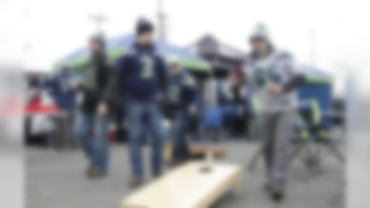 Seattle Seahawks fan Mike Braaten, right, tosses a beanbag as he plays a game of cornhole while tailgating before an NFL football NFC wild card playoff game against the Detroit Lions, Saturday, Jan. 7, 2017, in Seattle. (AP Photo/Stephen Brashear)