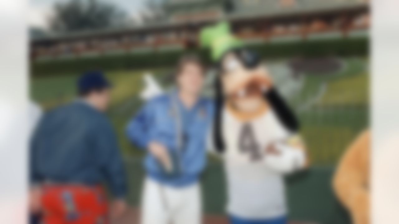 Heisman Trophy finalist Jim Harbaugh is held by Goofy, who sports the quarterback's jersey number, as the Michigan Wolverines tackled Disneyland on Saturday, Dec. 27, 1986 in Anaheim, CA during a break in their practice schedule for the upcoming Rose Bowl. (AP Photo/Bob Galbraith)