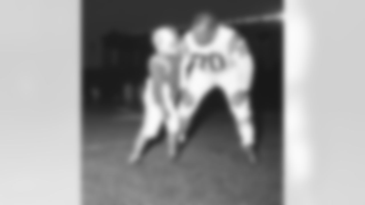 Stevie MacGregor, 7, of suburban Oak Park shoves his 60 pounds against Baltimore Colt tackle Art Donovan, 6 feet, 3 inches, who weights 270 pounds on August 12, 1960 in Chicago. Professional championship team worked out on August 11 at Chicago's Soldier Field where they play the College All Stars August 12. (AP Photo/PC)