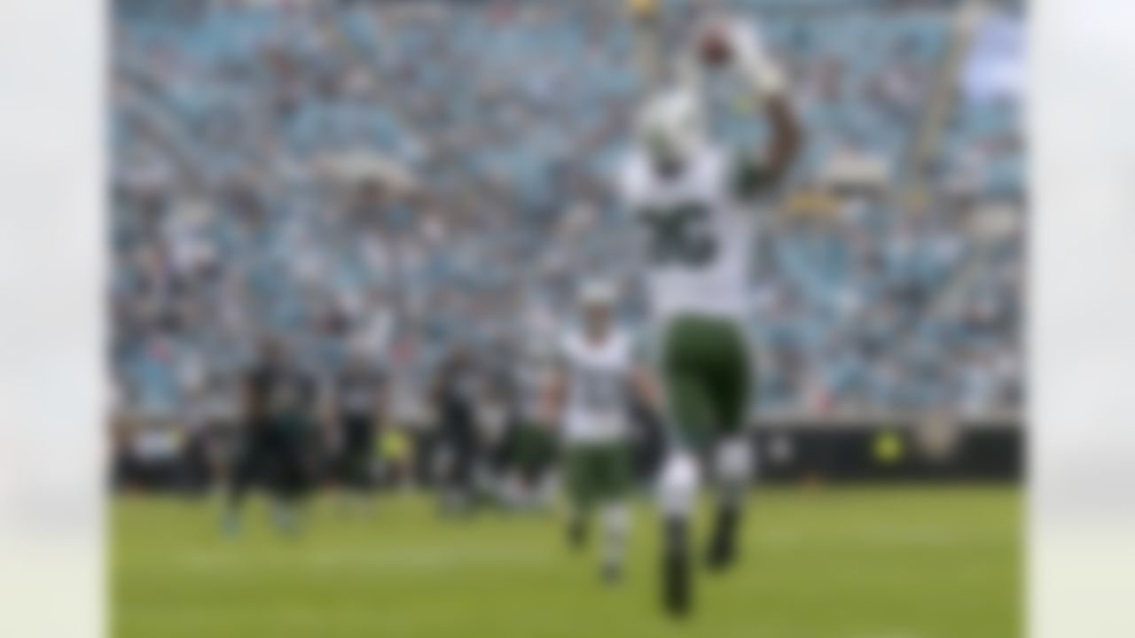 New York Jets defensive back Ellis Lankster (26) intercepts a pass as free safety Eric Smith (33) watches near the end of the fourth quarter during an NFL football game against the Jacksonville Jaguars in Jacksonville, Fla., Sunday, Dec. 9, 2012. The Jets won 17-10.(AP Photo/Phelan M. Ebenhack)