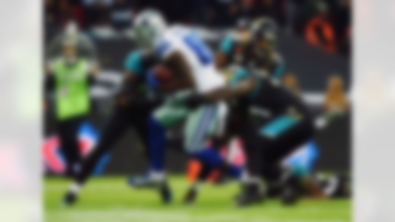 Dallas Cowboys wide receiver Dez Bryant (88) makes a touchdown run as Jacksonville Jaguars linebacker Dekoda Watson (57) and defensive end Chris Clemons (91) defend during the first half of an NFL football game at Wembley Stadium, London, Sunday, Nov. 9, 2014. (AP Photo/Tim Ireland)