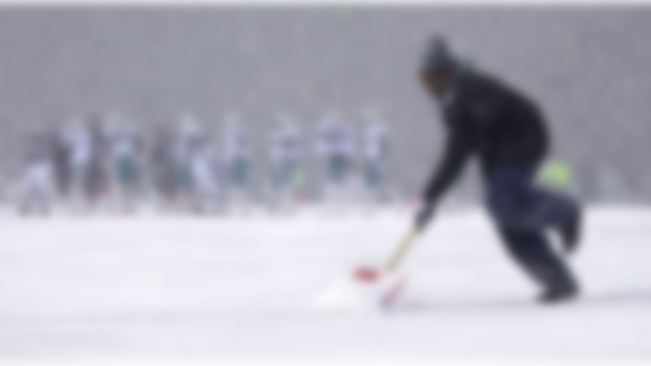 A member of the grounds crew scurries across the goaline to clear snow in between plays during the Miami Buffalo game in Orchard Park, N.Y., Sunday, Dec. 1, 2002. Buffalo won 38-21. (AP Photo/Kevin Rivoli)