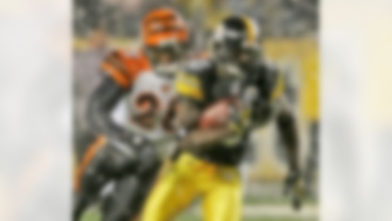 Pittsburgh Steelers receiver Santonio Holmes (10) runs after catching a pass from quarterback Ben Roethlisberger as Cincinnati Bengals cornerback Leon Hall (29) moves in to make the tackle during the second quarter of a NFL football game in Pittsburgh, Thursday, Nov. 20, 2008. (AP Photo/Gene J. Puskar)