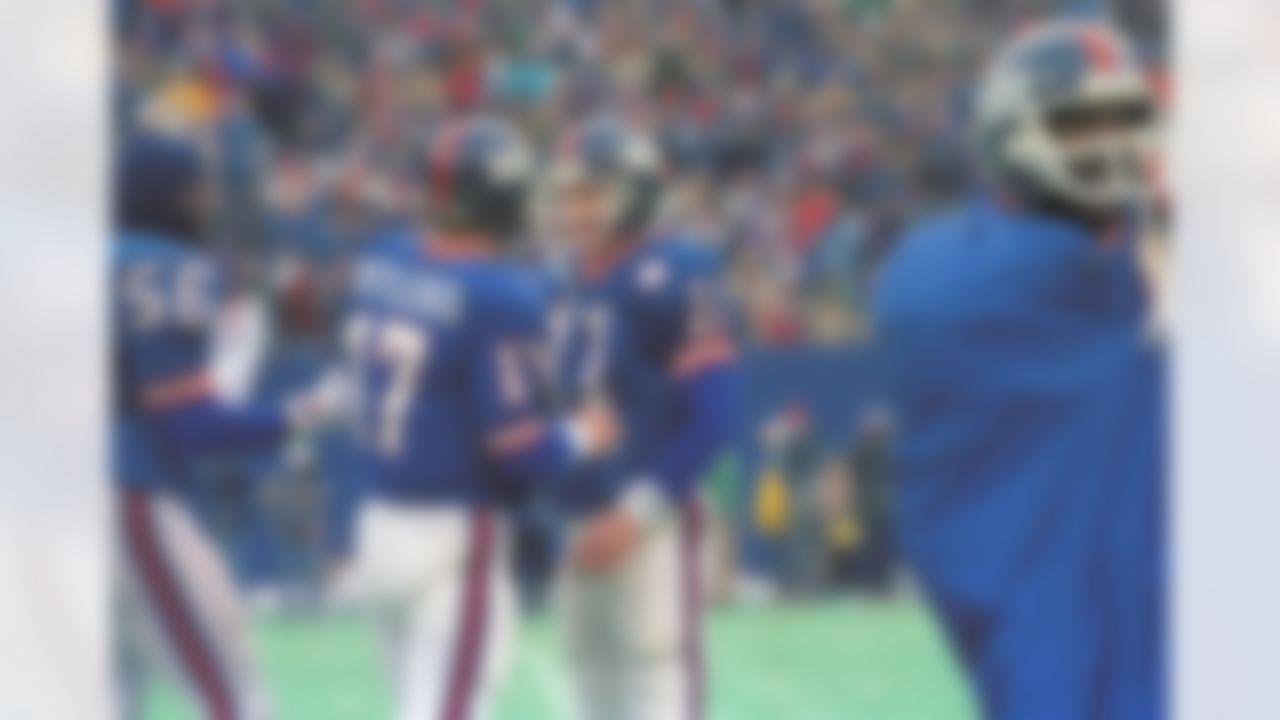 Phil Simms, the New York Giants quarterback, right, is congregated by teammate Jeff Rutledge on the sideline during Sunday's NFL playoff game against the San Francisco 49ers. Simms led the Giant?s to a 49-3 win shown Jan. 4, 1987 in East Rutherford, N.J. (AP Photo/David Fields)