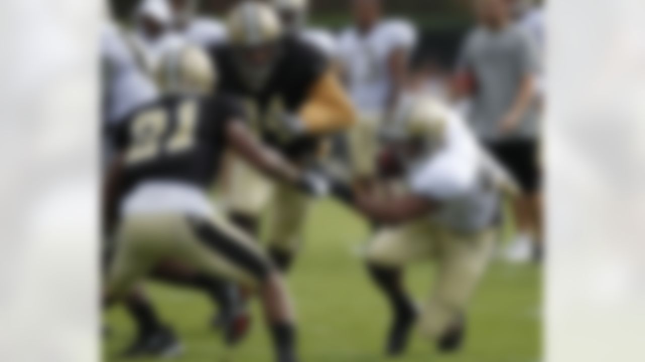 New Orleans Saints running back Pierre Thomas (23) tries to get past cornerback Patrick Robinson (21) and defensive end Cameron Jordan (94) during training camp at their NFL football training facility in Metairie, La., Saturday, July 28, 2012. (AP Photo/Gerald Herbert)
