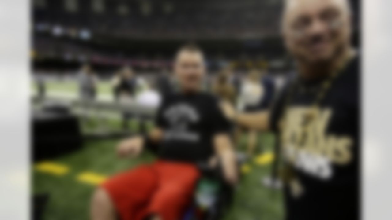 Former New Orleans Saints player Steve Gleason, who is suffering from ALS, is ushered onto the field before an NFL football game against the Philadelphia Eagles at the Mercedes-Benz Superdome in New Orleans, Monday, Nov. 5, 2012. (AP Photo/Bill Haber)