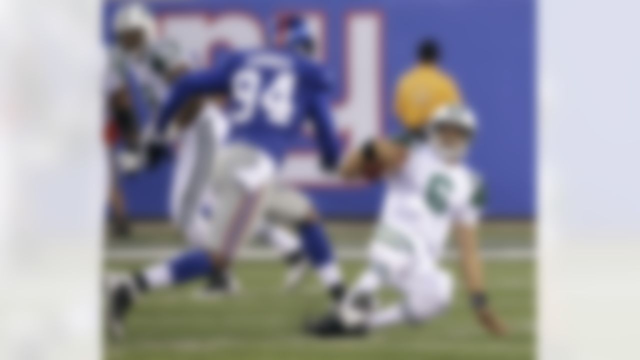 New York Jets quarterback Mark Sanchez, right, slides to avoid a tackle by New York Giants' Mathias Kiwanuka (94) during the first quarter of an NFL preseason football game Monday, Aug. 29, 2011, in East Rutherford, N.J. (AP Photo/Julio Cortez)