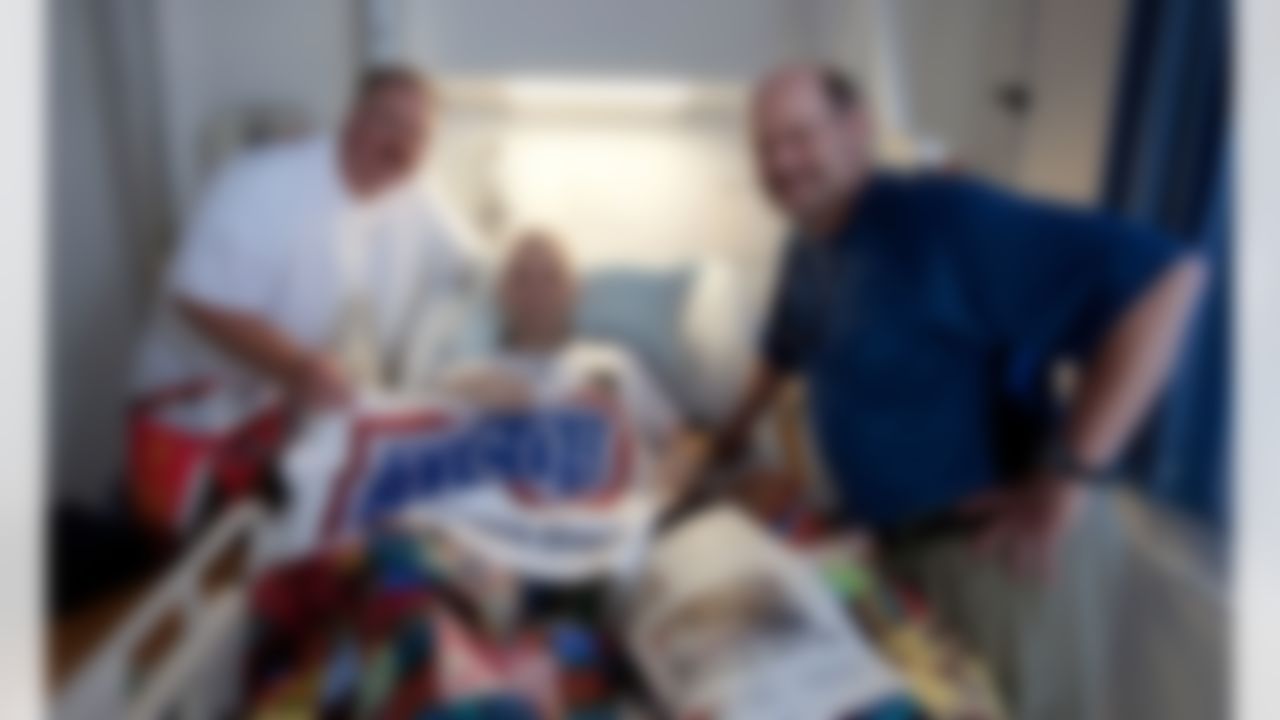 Andy Reid, Philadelphia Eagles head coach (l) and Brad Childress, Minnesota Vikings head coach (r) pose for a photo with recuperating Maj Michael Maritzen during a tour stop at Ladsthul Regional Medical Center in Germany on June 29, 2010. For the second consecutive year, the National Football League (NFL) deployed four of its most sought-after coaches to the Persian Gulf to visit troops as part of a week-long USO/Armed Forces Entertainment tour. (Fred Greaves/USO)