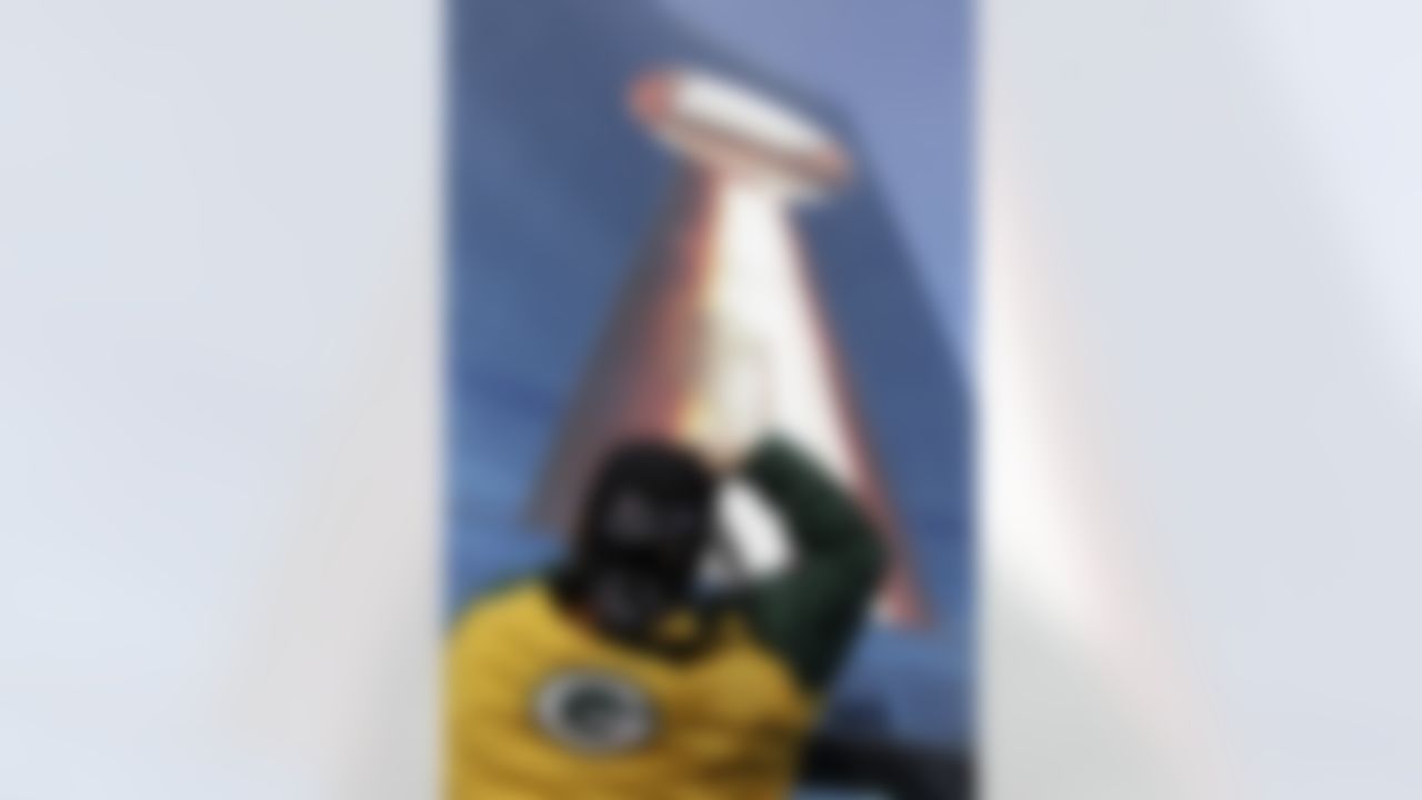Jeff Bahls photographs a Vince Lombardi Trophy logo on the side of a downtown Indianapolis hotel, Friday, Feb. 3, 2012. The New England Patriots are scheduled to play the New York Giants in Super Bowl XLVI on Feb. 5. (AP Photo/David Duprey)
