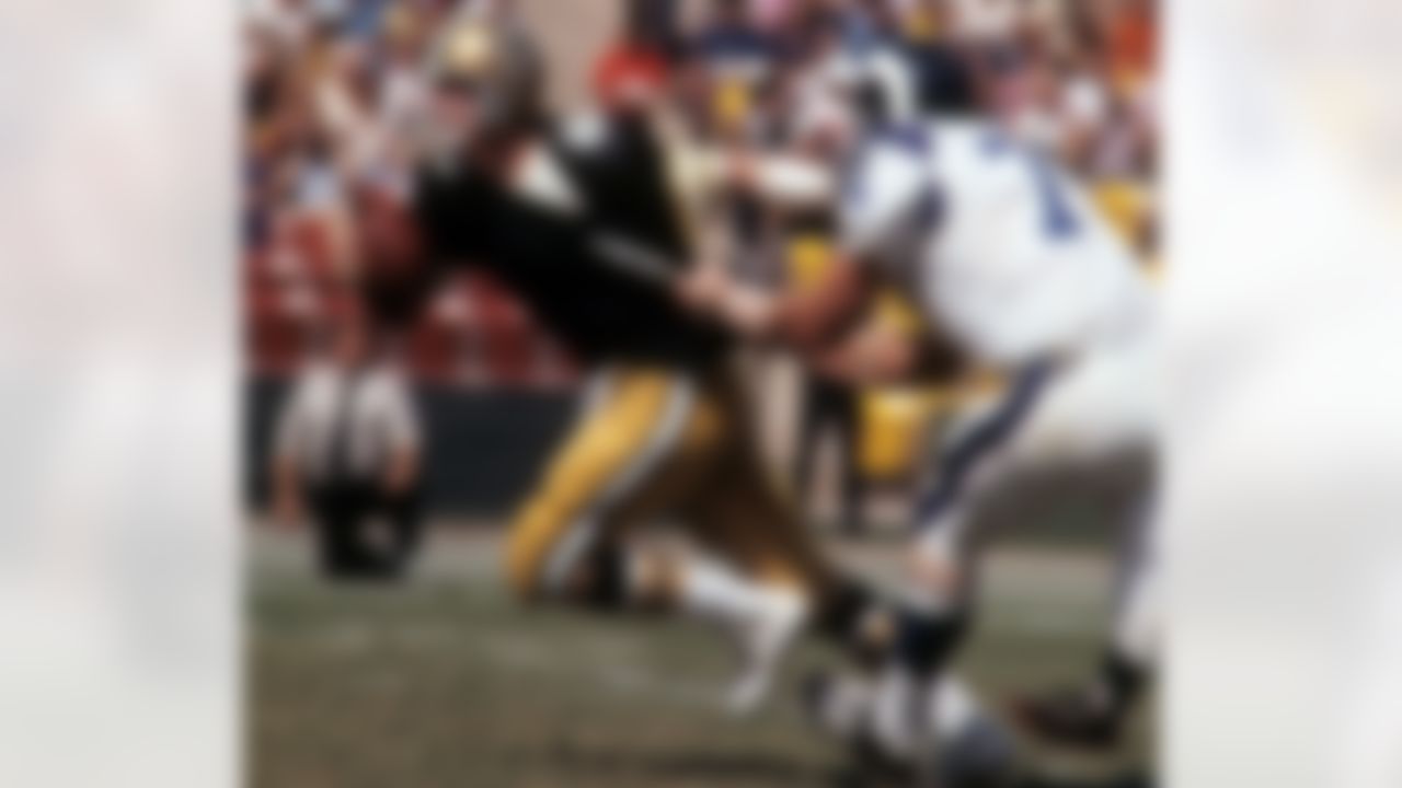 LOS ANGELES - SEPTEMBER 17: Quarterback Archie Manning #8 of the New Orleans Saints is grabbed by the jersey by defensive tackle Merlin Olsen #74 of the Los Angeles Rams at the Los Angeles Memorial Coliseum on September 17, 1972 in Los Angeles, California. The Rams defeated the Saints 34-14. (AP Photo/NFL Photos)
