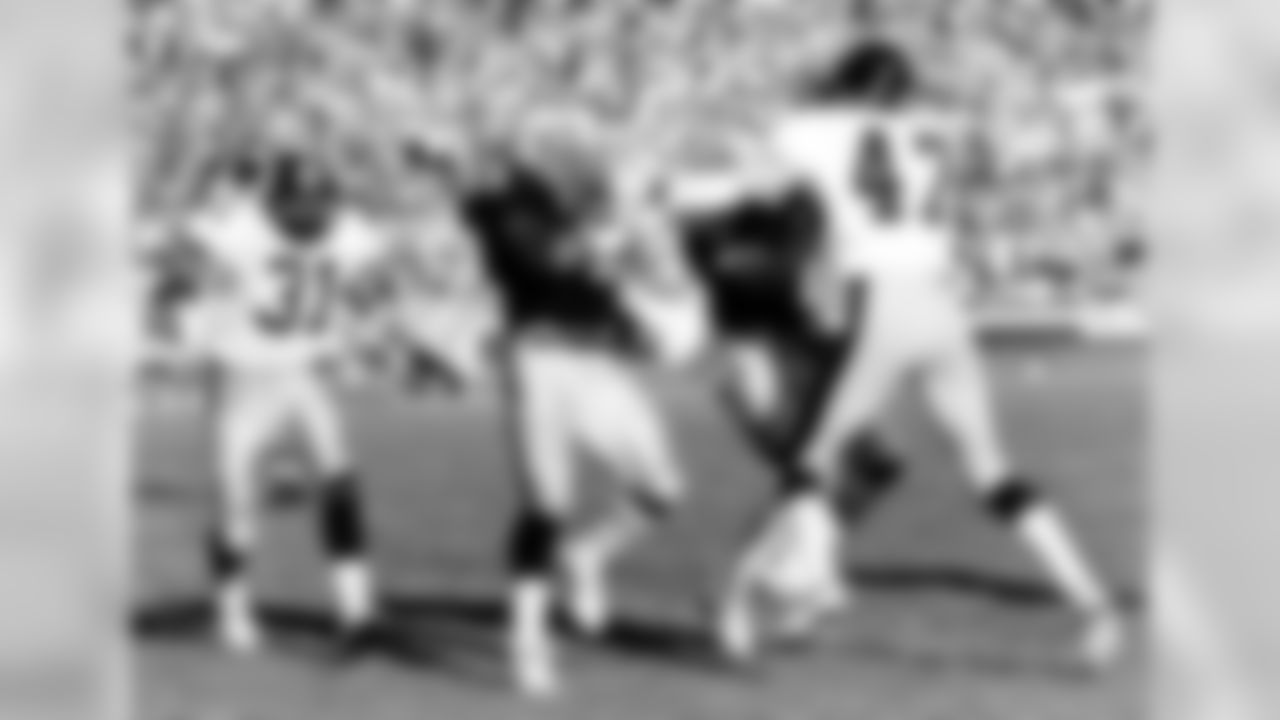 Los Angeles Raiders running back Kenny King (33) scores a 9-yard touchdown behind the blocking of wide receiver Malcolm Barnwell (80) of Pittsburgh Steelers cornerback Mel Blount (47) during the AFC Divisional Playoff, a 38-10 Raiders victory on January 1, 1984, at the Los Angeles Memorial Coliseum in Los Angeles, California. (National Football League)