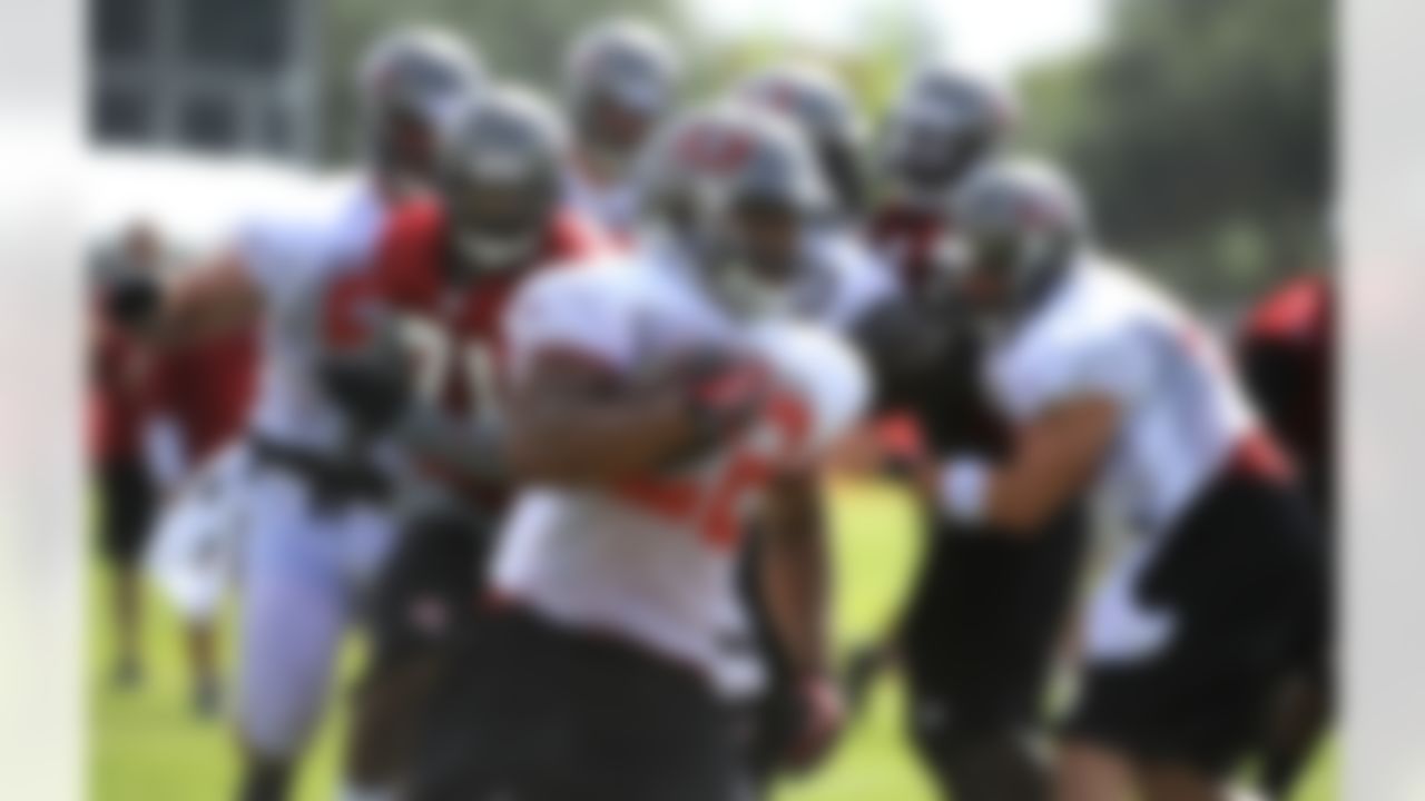 Tampa Bay Buccaneers running back Doug Martin, center, evades the pack and runs for during NFL football training camp, Friday, July 27, 2012, in Tampa, Fla. (AP Photo/Brian Blanco)