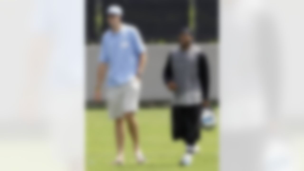 Carolina Panthers' Steve Smith, right, laughs with tennis player John Isner, left, after football practice in Charlotte, N.C., Wednesday, June 2, 2010. (AP Photo/Chuck Burton)