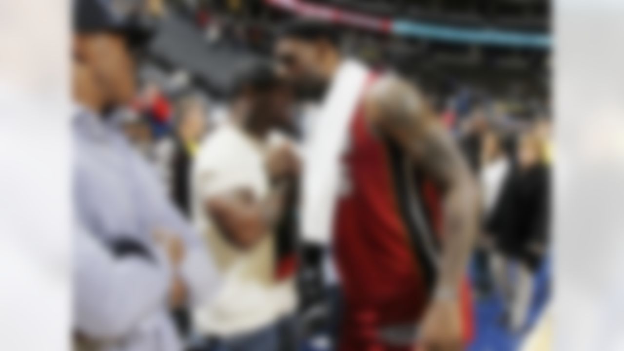 Miami Heat forward LeBron James, right, is congratulated by Denver Broncos running back Willis McGahee, center, and wide receiver Demaryius Thomas as James leaves the court after Miami's 98-93 victory over the Denver Nuggets in an NBA basketball game in Denver on Thursday, Nov. 15, 2012. (AP Photo/David Zalubowski)