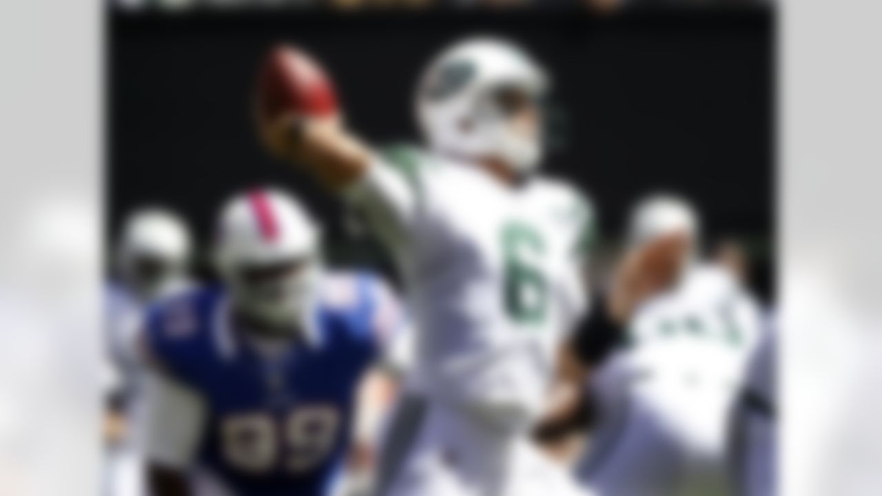 As Buffalo Bills defensive tackle Marcell Dareus (99) tries to make a tackle, New York Jets quarterback Mark Sanchez (6) throws a pass during the first half of an NFL football game at MetLife Stadium Sunday, Sept. 9, 2012, in East Rutherford, N.J. (AP Photo/Mel Evans)