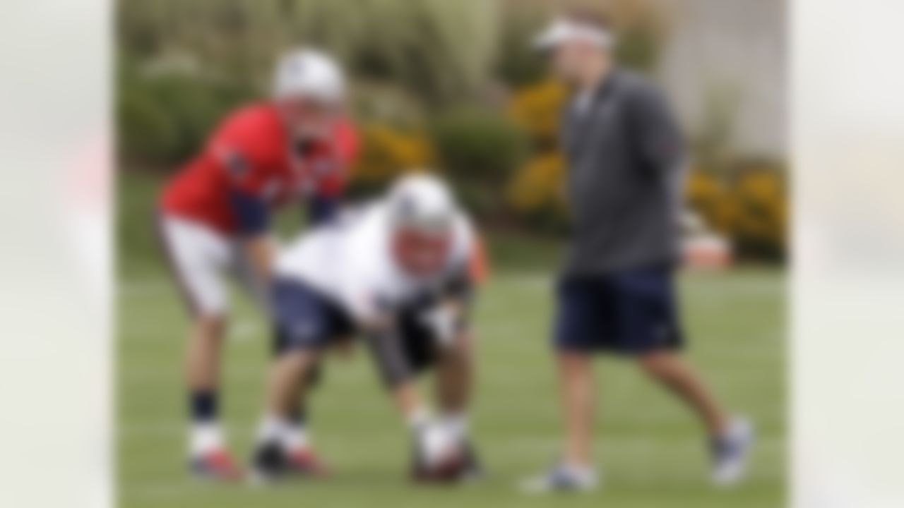 New England Patriots quarterback Tom Brady (12) and center Dan Koppen, center, work on their technique as offensive coordinator Josh McDaniels, right, looks on during practice on the first day of training camp at the NFL football team's facility in Foxborough, Mass., Thursday, July 26, 2012. (AP Photo/Stephan Savoia)