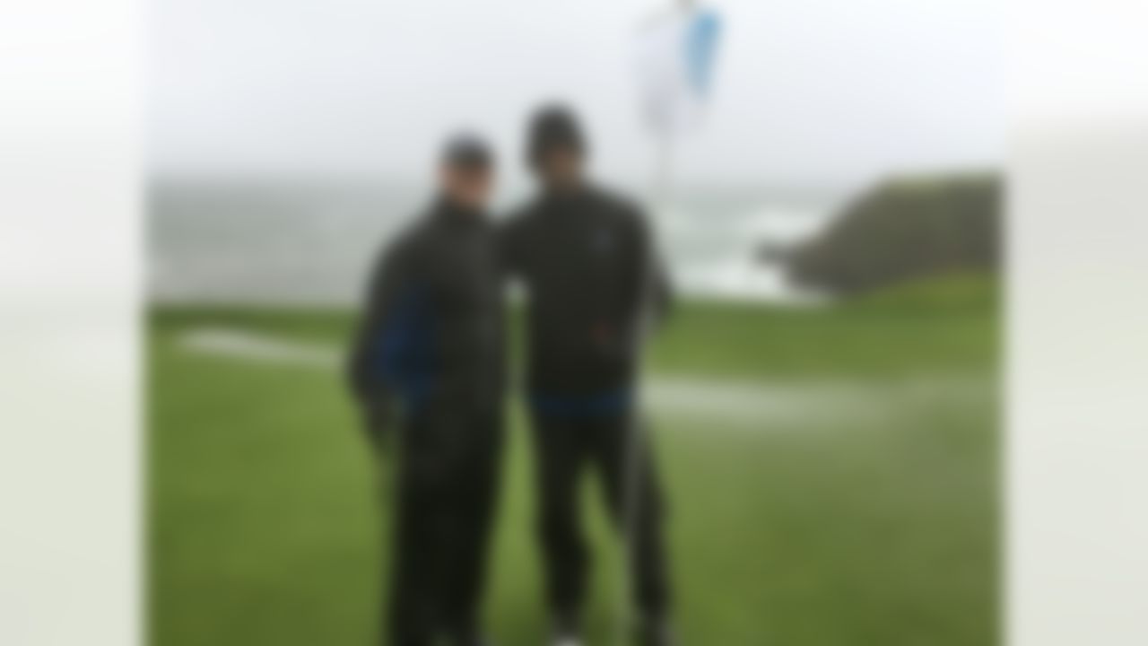 PGA Tour veteran Jerry Kelly, left, and Green Bay quarterback Aaron Rodgers pose on the 8th green at Pebble Beach, Calif., on Tuesday, Feb. 7, 2017, while playing in 40 mph wind and rain. Only at Pebble Beach are players willing to go out in such miserable conditions. (AP Photo/Doug Ferguson)