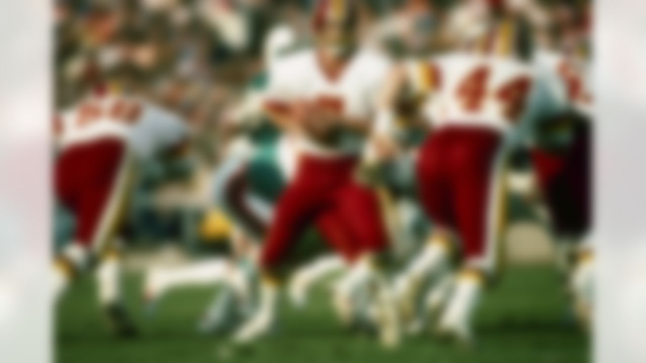 Washington Redskins quarterback Joe Theismann hands off to running back John Riggins during a 27 - 17 victory over the Miami Dolphins in Super Bowl XVII on January 30, 1983 at the Rose Bowl in Pasadena, CA. (AP Photo/Al Messerschmidt)