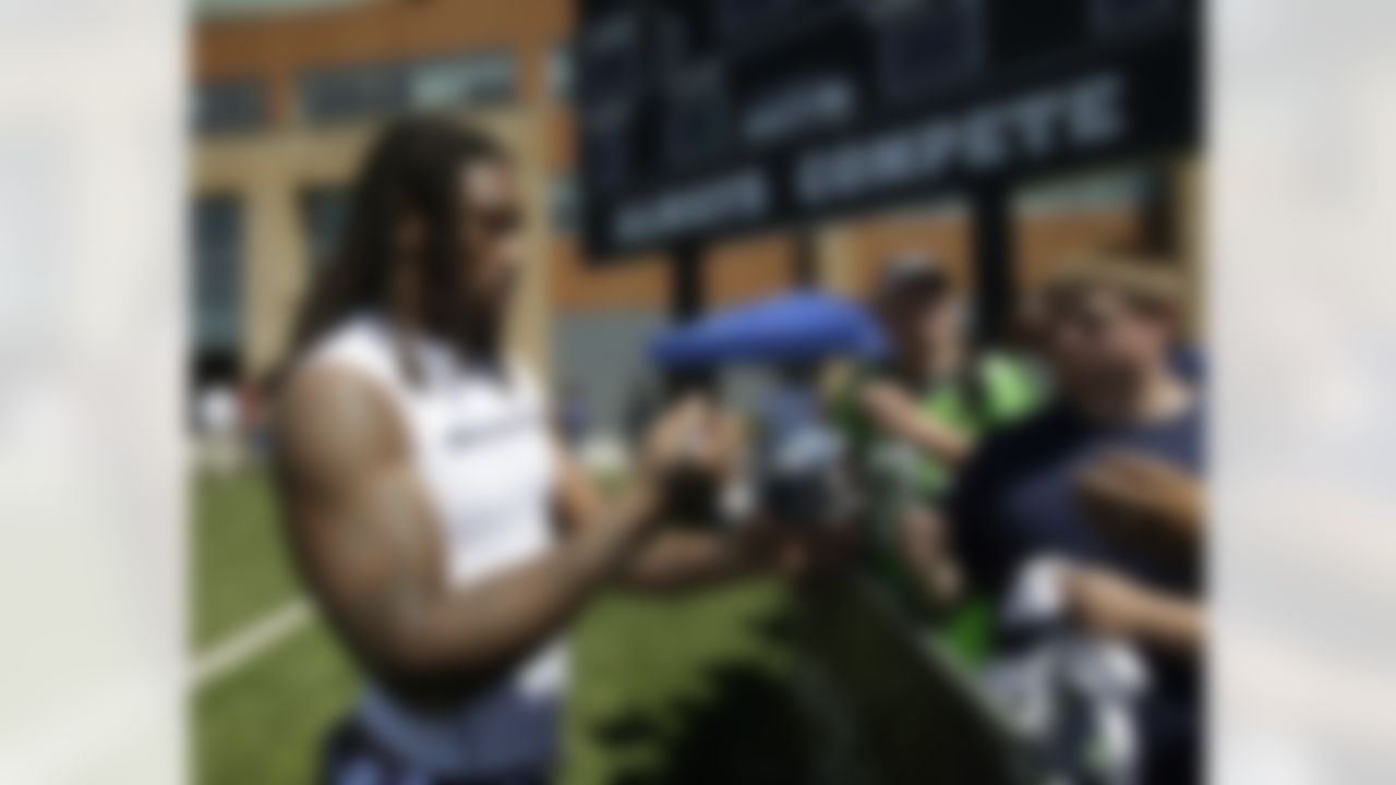 Seattle Seahawks' Bruce Irvin signs autographs, Friday, Aug. 3, 2012, during NFL football training camp, in Renton, Wash. (AP Photo/Ted S. Warren)