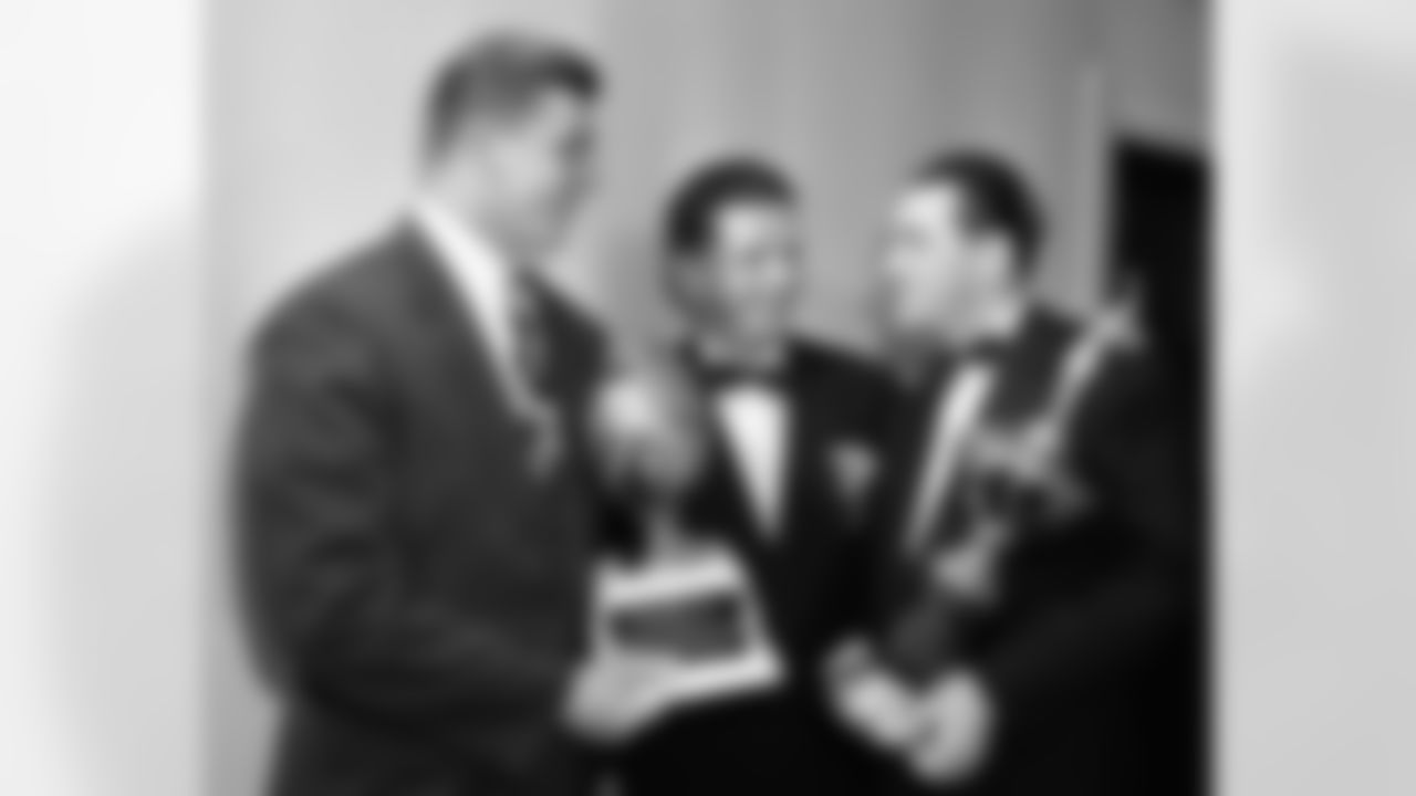 Chuck Bednarik, left, named "Lineman of the Week," holds his trophy at the Philadelphia Sports Writers Association awards, Jan. 31, 1949. With him are Jack Wilson and Lou Boudreau. (AP Photo/Warren M. Winterbottom)